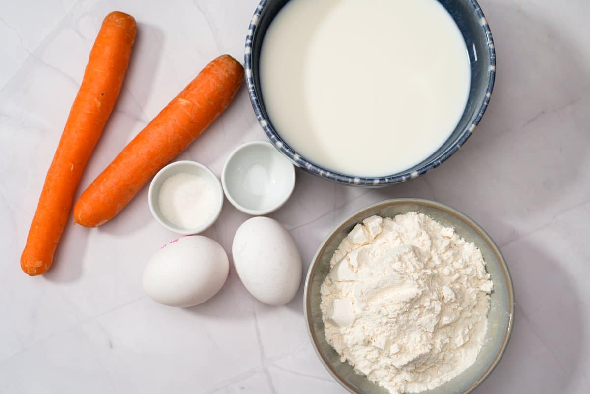 Porkkana, maito, jauhot  munat ja mausteet pienissä astioissa. 