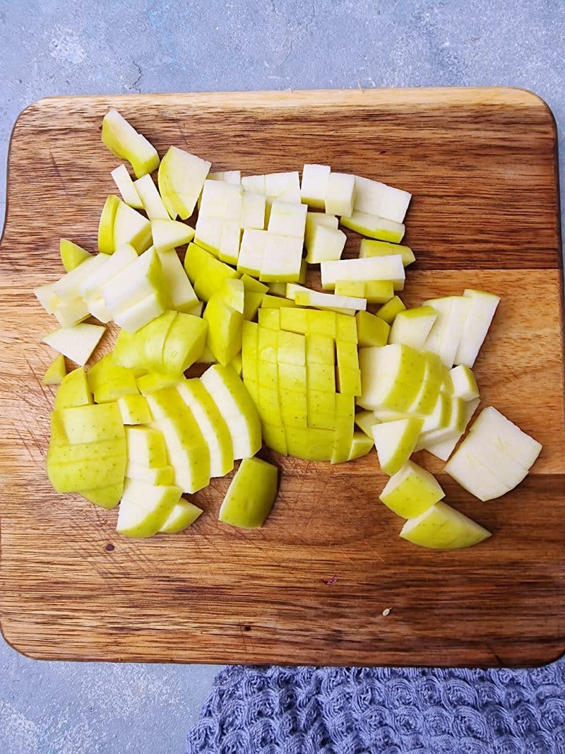Omena kuutioituna pieneksi leikkuulaudalla. 