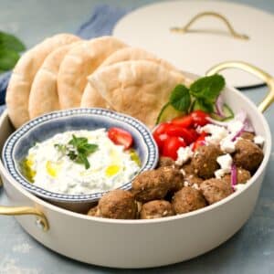 Isossa kasarissa lihapullia, tsatsikia, pitaleipiä, salaattia ja kuskusta.