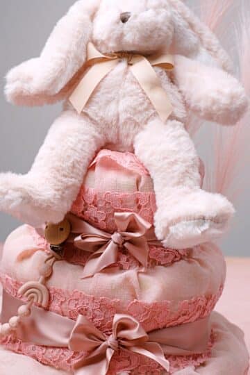 Vaaleanpunainen vaippakakku joka päällystetty kankaalla ja koristeena vaaleanpunainen nalle.