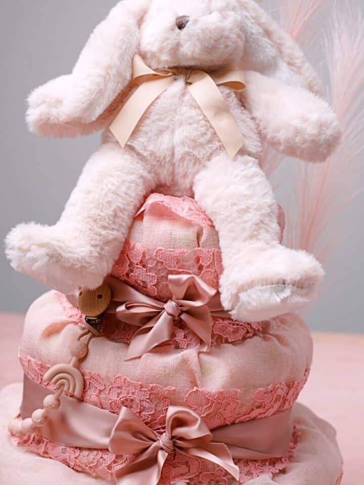 Vaaleanpunainen vaippakakku joka päällystetty kankaalla ja koristeena vaaleanpunainen nalle.