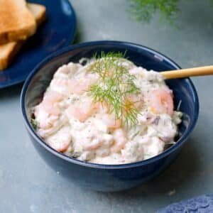 Sinisessä kulhossa raputahnaa jota koristaa tilli