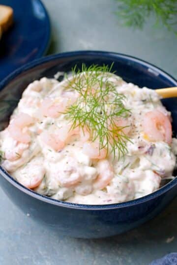 Sinisessä kulhossa raputahnaa jota koristaa tilli