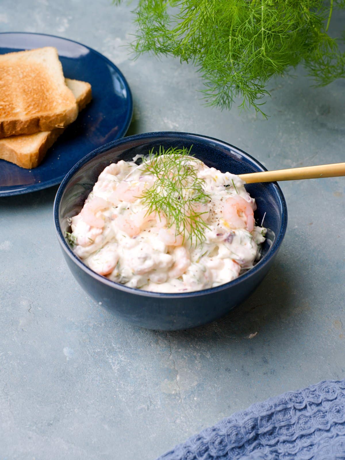 Sinisessä kulhossa raputahnaa joka koristeltu tillinoksalla